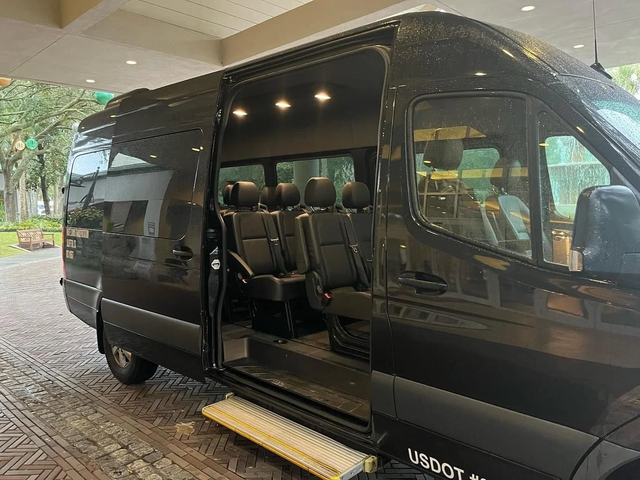 Black Sprinter interior with executive passenger seating and open side door