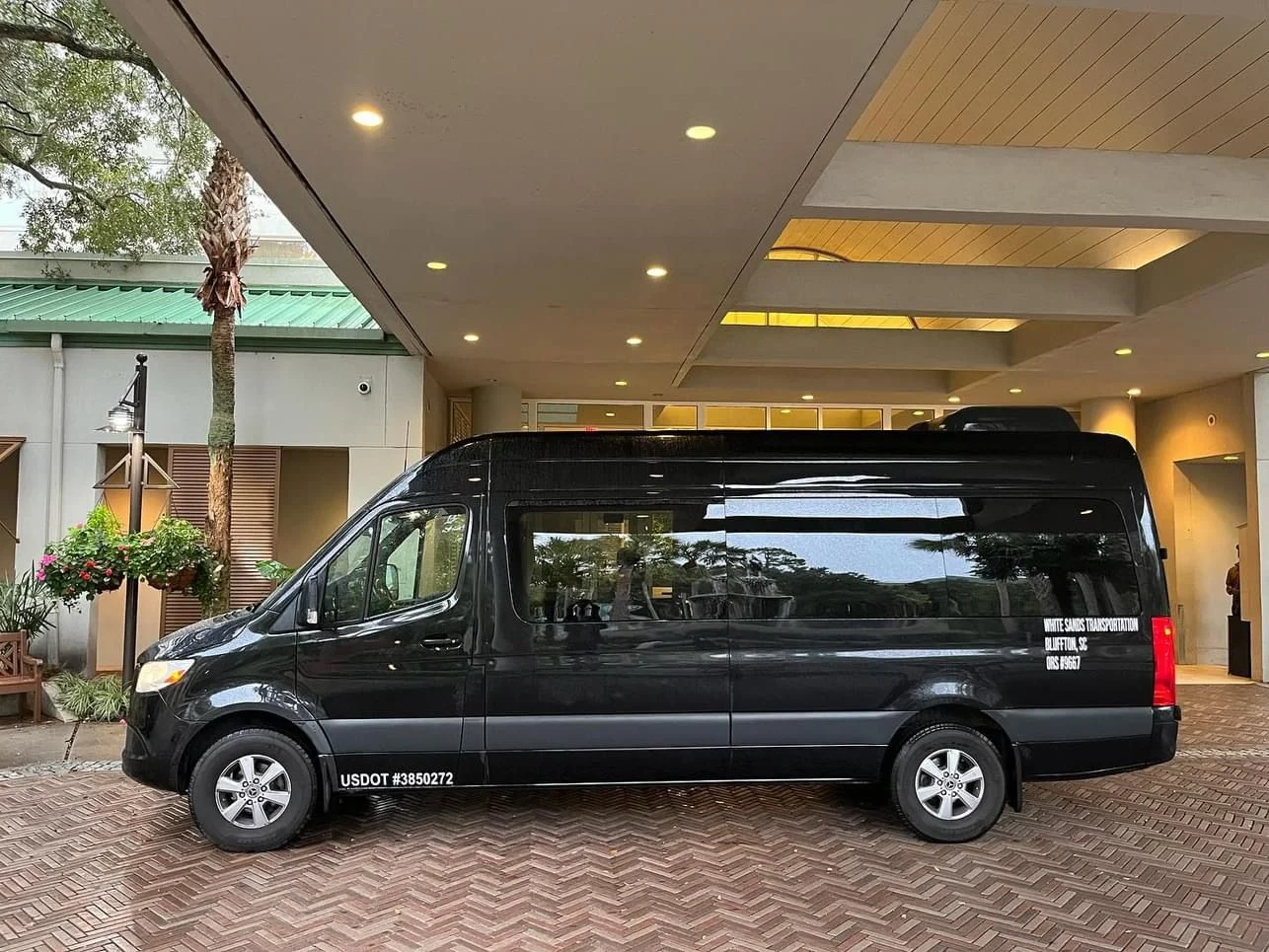 Black Sprinter waiting at a covered hotel entrance